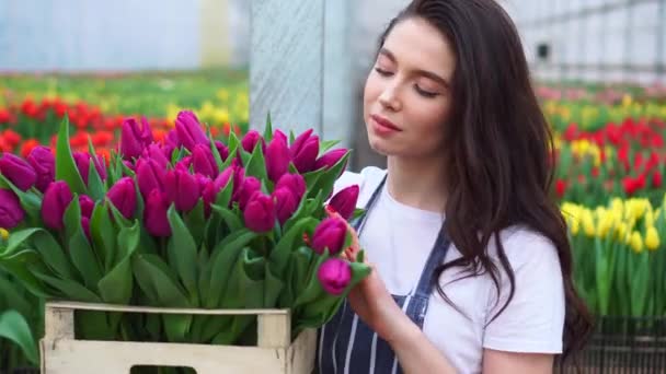 Floristería mujer sostiene una caja con flores . — Vídeo de stock