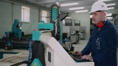 Bir fabrika işçisi kontrol panelinde duruyor..