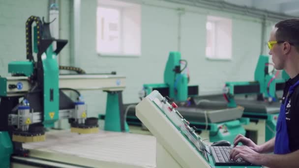 Um trabalhador da fábrica está de pé no painel de controle . — Vídeo de Stock