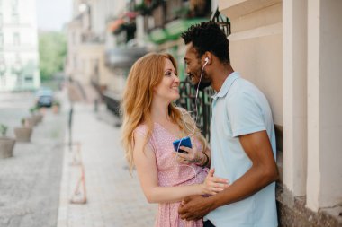 Genç bir çift kulaklıkla müzik dinliyor..