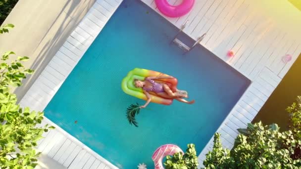 A young woman relaxes in the pool. — Stock Video