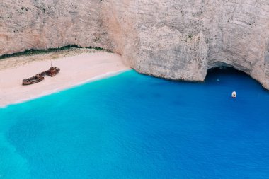 Harap olmuş eski bir gemi, deniz kıyısında uzanıyor. Yunanistan.