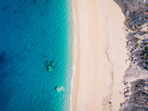 Vista aérea de arriba hacia abajo de una playa de arena blanca a orillas de un hermoso mar turquesa . — Foto de Stock