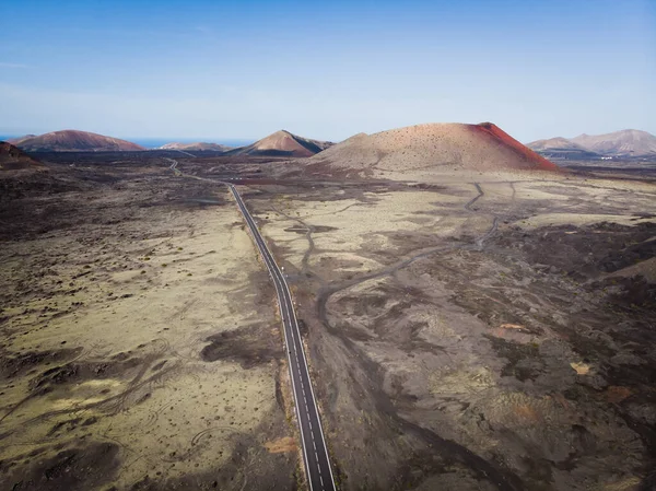 Droga wśród kraterów na bezludnej pustyni. — Zdjęcie stockowe