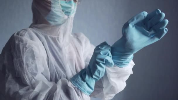 Medic in a protective suit puts on gloves. — Stock Video