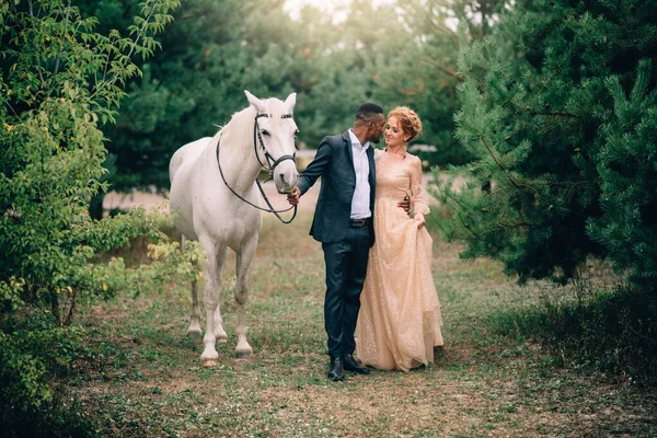 Pareja feliz caminando juntos en el rancho con caballos —  Fotos de Stock