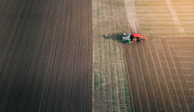 Bir traktör baharda bir tarlada çalışır..