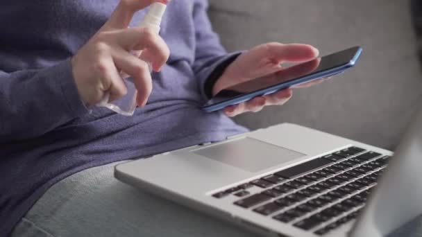 Жінка натирає смартфон антибактеріальною серветкою . — стокове відео