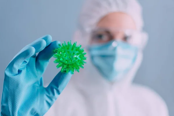 Der Arzt hält ein Modell des Coronavirus in der Hand. — Stockfoto