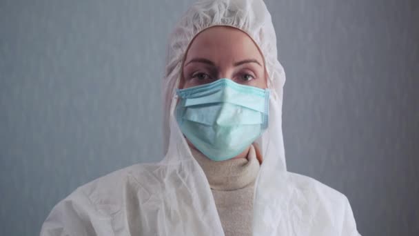 Медсестра надевает защитный костюм . — стоковое видео