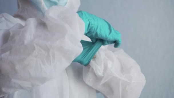 Médecin en combinaison de protection met des gants . — Video