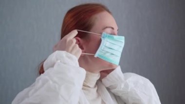 Hemşire koruyucu bir maske takar..