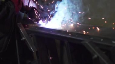 A welder is welding metal construction elements, close-up.