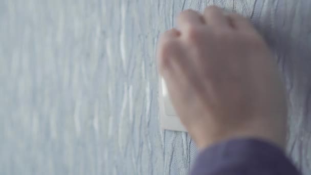 Жінка дезінфікує вмикач на стіні . — стокове відео