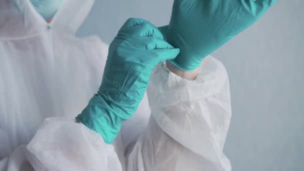 Sanitäter im Schutzanzug zieht Handschuhe an. — Stockvideo
