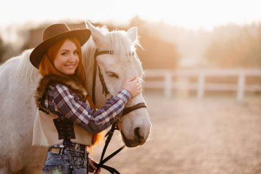 Çiftlikte at okşayan bir kadın..