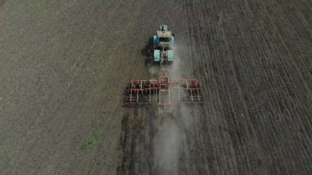Ein Traktor mit Egge bearbeitet das Land. — Stockvideo