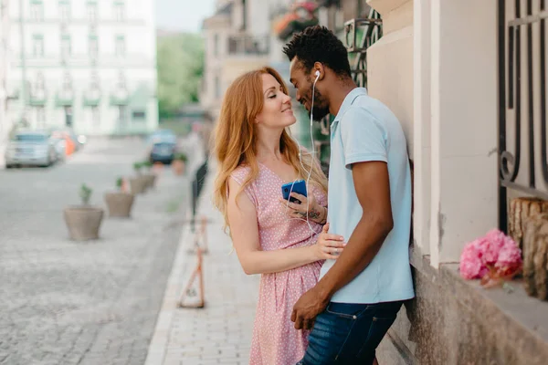 Een jong stel luistert naar muziek op de hoofdtelefoon. — Stockfoto