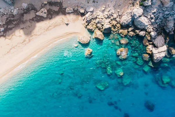 Vista aérea de arriba hacia abajo de una playa de arena blanca a orillas de un hermoso mar turquesa . — Foto de Stock