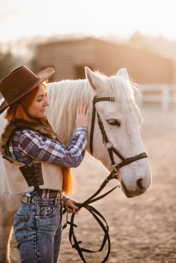 Çiftlikte at okşayan bir kadın..