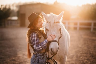 Çiftlikte at okşayan bir kadın..