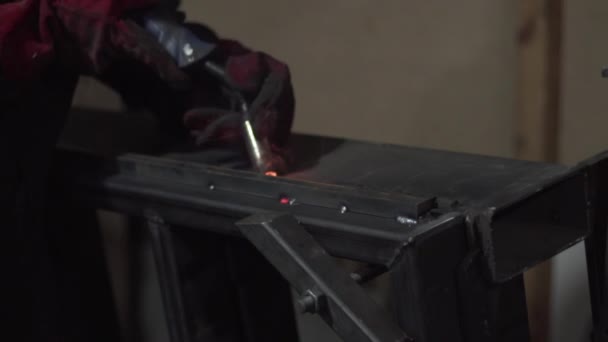 Un soldador está soldando elementos de construcción de metal, primer plano . — Vídeo de stock