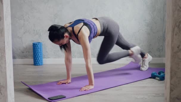 Uma mulher entra para praticar esportes em casa . — Vídeo de Stock