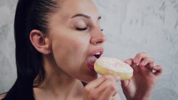 Woman eating a donut, close-up. — Stock Video