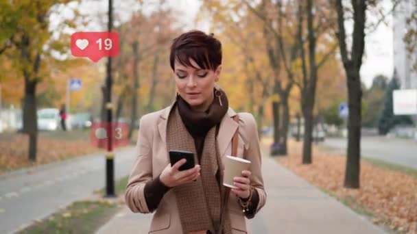 En kvinna använder en smartphone på gatan. — Stockvideo