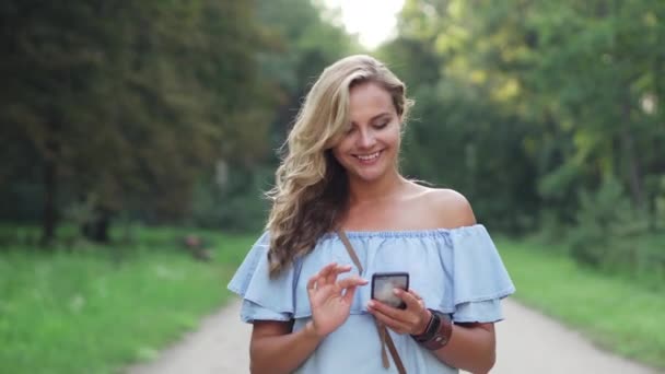 Een vrouw gebruikt een smartphone op straat. — Stockvideo