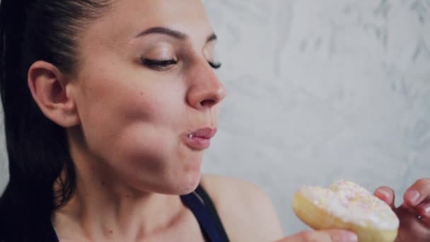 Woman eating a donut, close-up. — Stock Video