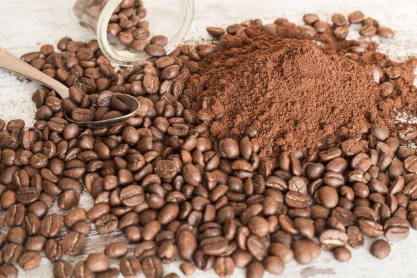 Granos de café derramados y molidos sobre una mesa — Foto de Stock