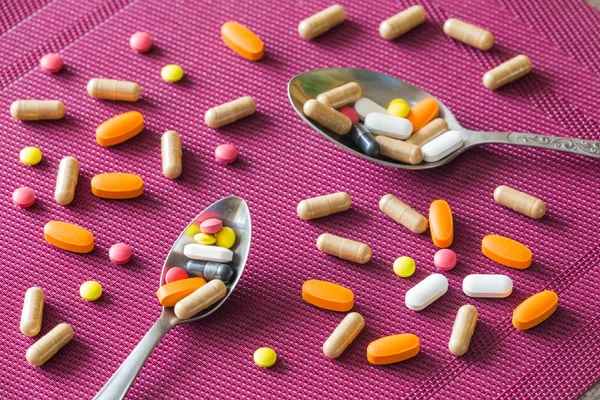 Pílulas espalhadas na mesa — Fotografia de Stock