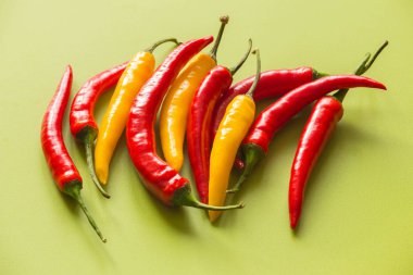 Yeşil bir arka plan üzerinde renkli sıcak kırmızı biber