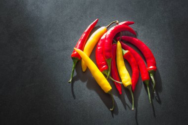 Taş karanlık bir tablo üzerinde renkli sıcak kırmızı biber