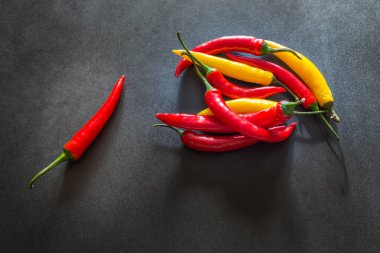 Taş karanlık bir tablo üzerinde renkli sıcak kırmızı biber