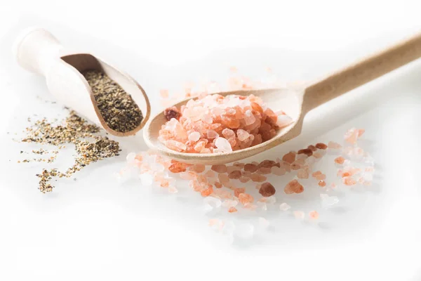 Himalaya salt och peppar på sked och vita bordet — Stockfoto