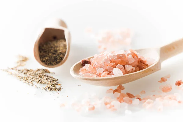 Himalaya salt och peppar på sked och vita bordet — Stockfoto