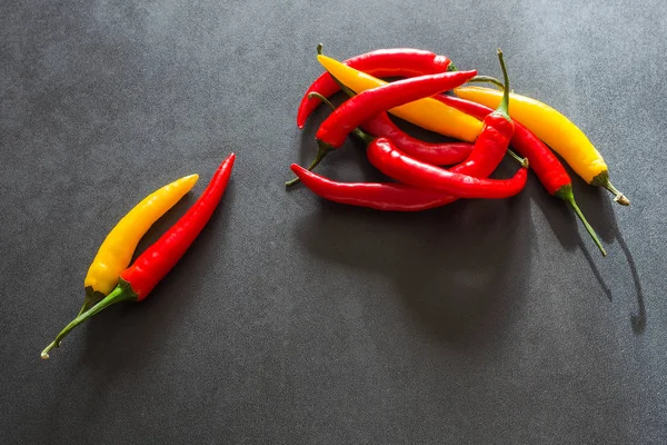 Taş karanlık bir tablo üzerinde renkli sıcak kırmızı biber