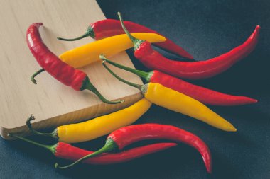 Taş karanlık bir tablo üzerinde renkli sıcak kırmızı biber