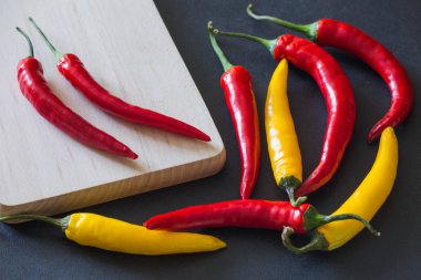 Taş karanlık bir tablo üzerinde renkli sıcak kırmızı biber