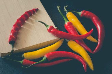 Taş karanlık bir tablo üzerinde renkli sıcak kırmızı biber