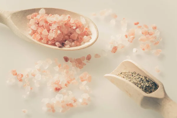 Himalaya salt och peppar på sked och vita bordet — Stockfoto