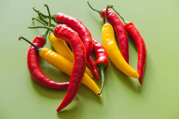 Yeşil bir arka plan üzerinde renkli sıcak kırmızı biber