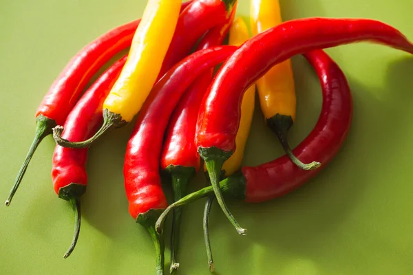 Yeşil bir arka plan üzerinde renkli sıcak kırmızı biber