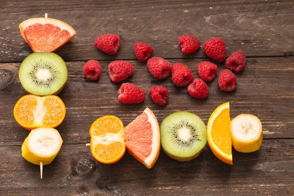 Espetos de frutas no fundo de madeira / o conceito de estilo de vida saudável — Fotografia de Stock