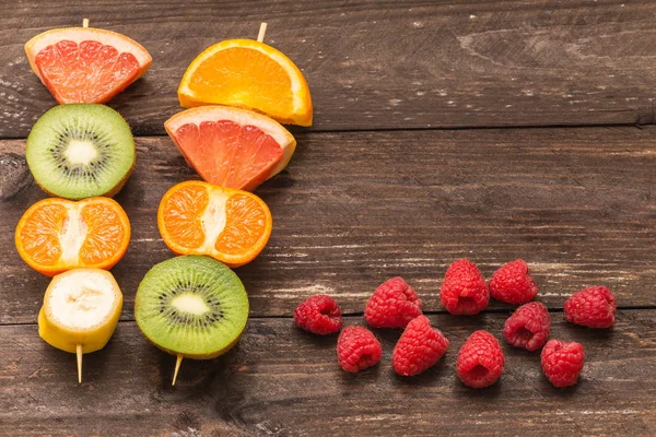 Espetos de frutas no fundo de madeira / o conceito de estilo de vida saudável com lugar para o texto — Fotografia de Stock