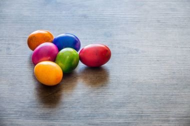 Ahşap masa üzerinde yumurta boyalı Paskalya renkli