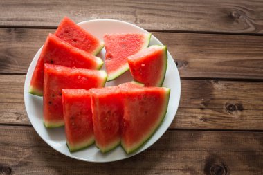 Ahşap arka plan üzerinde bir plaka üzerinde sulu karpuz.