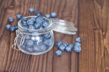 Ahşap bir masa üzerinde bir kavanoza yaban mersini